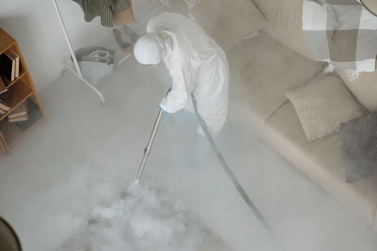 Biohazard cleanup technician in protective equipment, Lake Lotawana, MO
